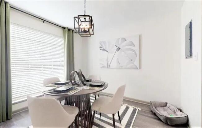A dining room with a table set for two and a white chair.
