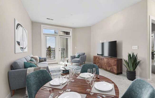 A modern dining room with a wooden table set for two.