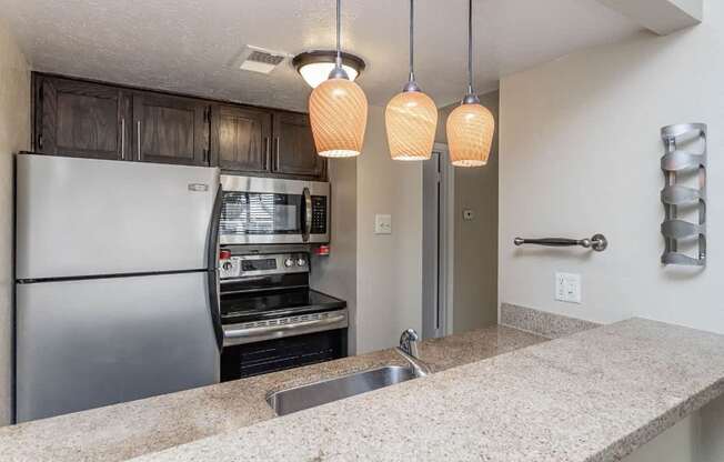 A kitchen with a stainless steel refrigerator and a built-in oven.