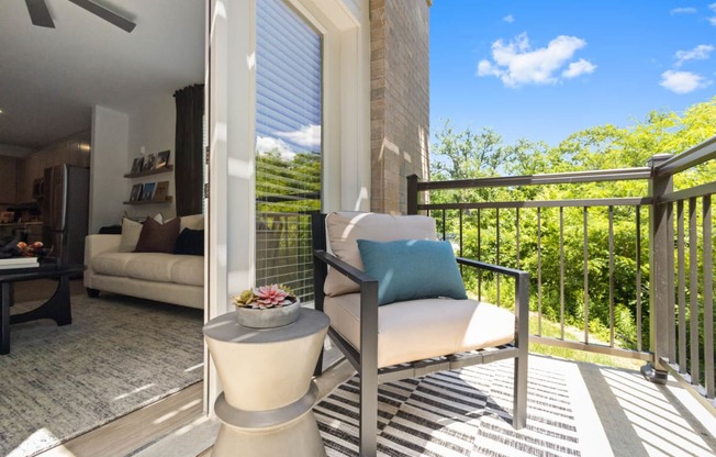 a patio with a chair and a table on a balcony