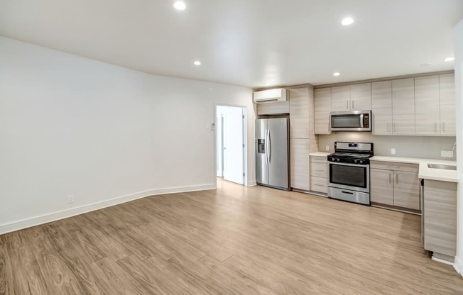 an empty living room with white walls and wood flooring