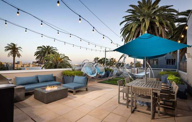 a patio with a firepit and chairs and tables