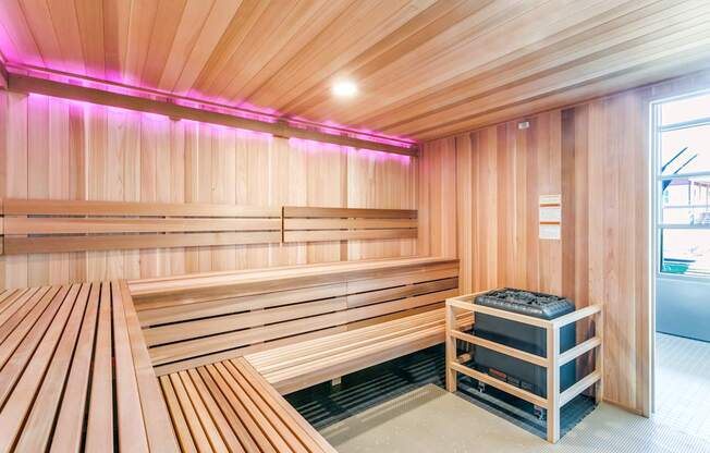 A sauna room with wooden benches and a heater.
