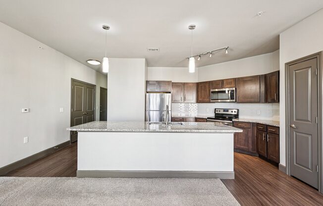 A modern kitchen with a white island and wooden cabinets.
