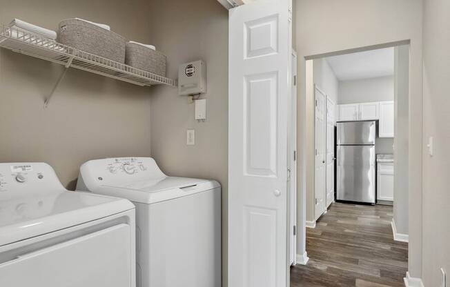 Apartment with a laundry room with a washer and dryer and a kitchen with a refrigerator