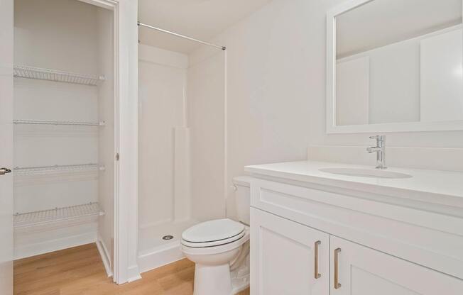A white bathroom with a toilet, sink, and medicine cabinet.