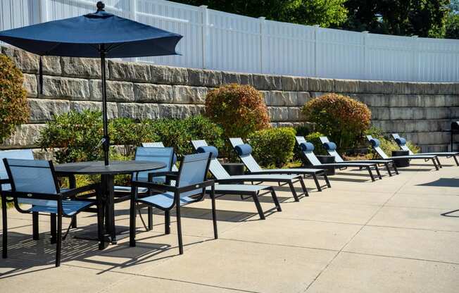 an outdoor patio with tables and chairs and an umbrella