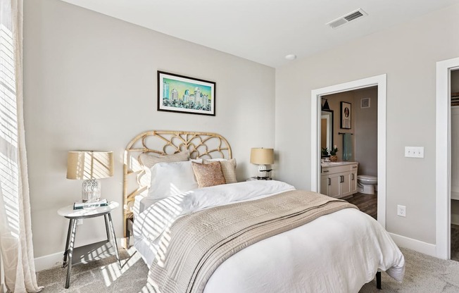 A bedroom with a large bed and a painting on the wall.