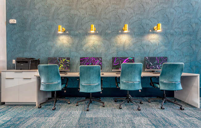 Four chairs are arranged around a desk with a computer on it.