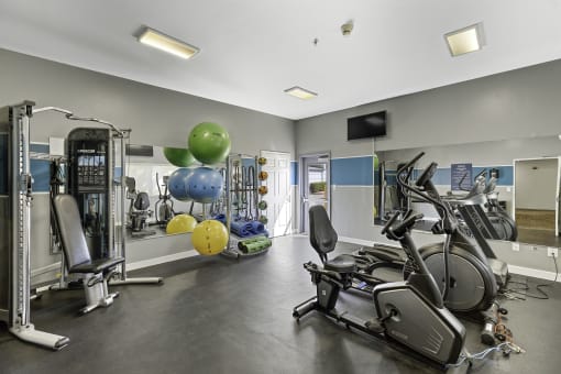 a gym with cardio equipment and weights  at Camelot Apartment Homes, Everett, WA, 98204