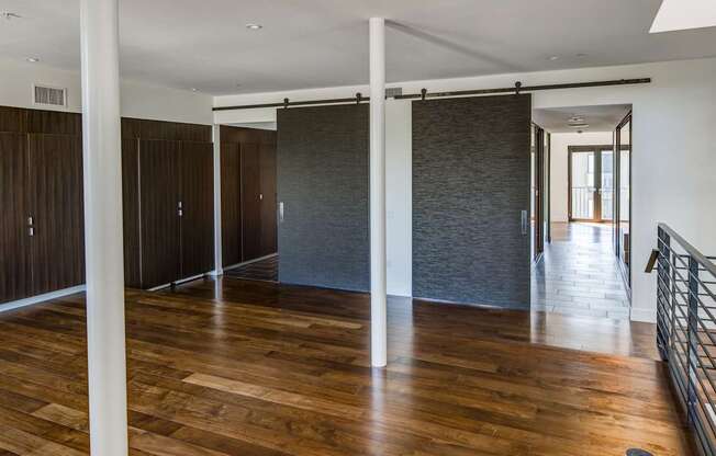 A room with wooden floors and white pillars.