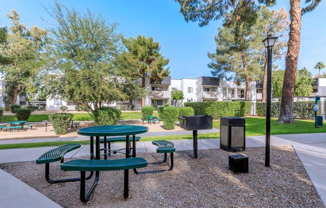 an empty park bench next to a picnic table