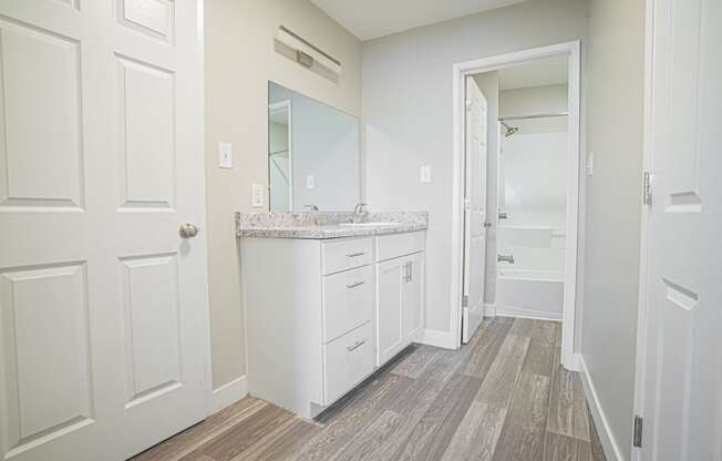 a white bathroom with a sink and a mirror