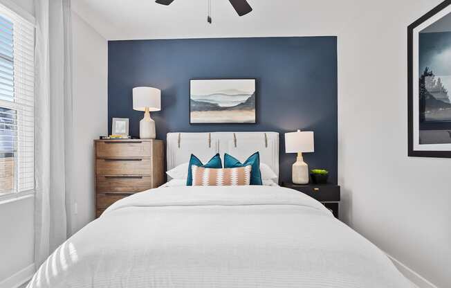 a bedroom with model furnishings and blue accent wall in a home at Sanctuary at Indian Creek