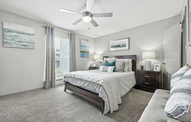 A bedroom with a large bed and a ceiling fan.