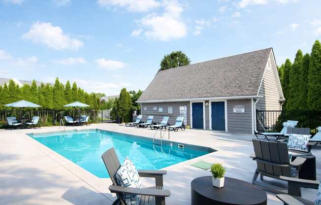A poolside area with chairs and a table.