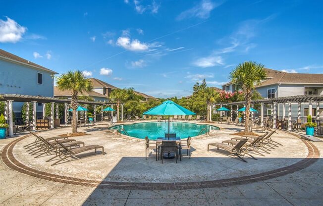 A large swimming pool surrounded by lounge chairs and umbrellas.