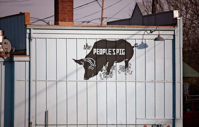 a sign on the side of a building with a cow on it