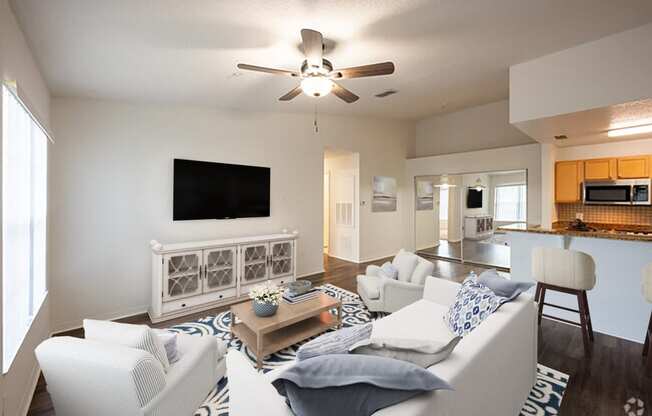 a living room with a white couch and a ceiling fan