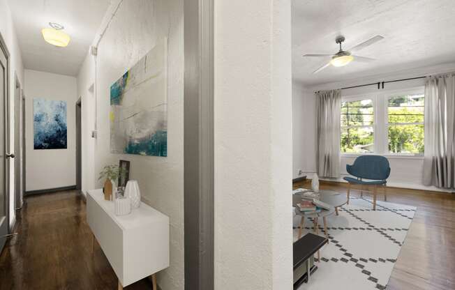 a living room with hardwood floors and white walls at Del Mor Apartments, Los Angeles, California
