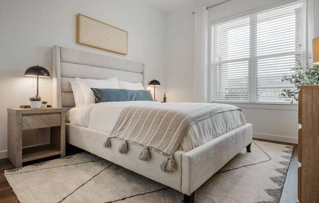 a bedroom with a bed and two windows