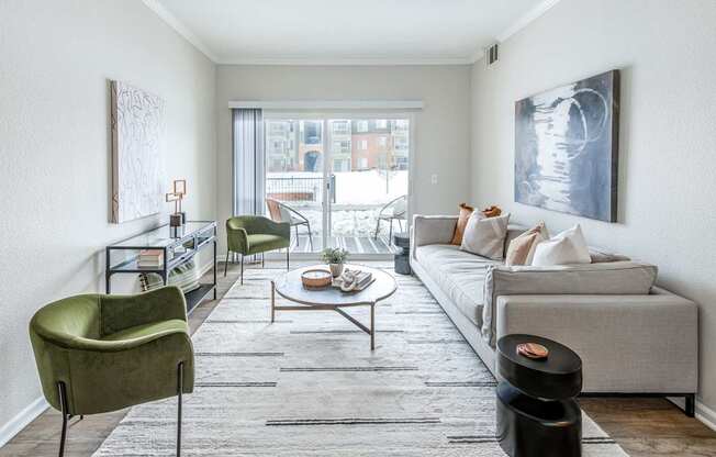 A living room with a grey couch, a green chair, and a coffee table.