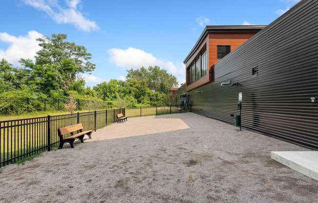 a large patio with two benches and a black fence