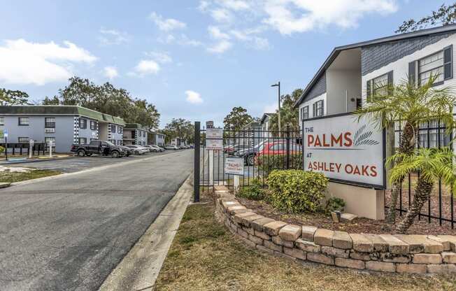 the sign for palms oaks at the entrance to a street with houses