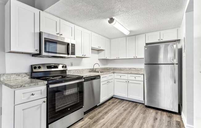 a kitchen with stainless steel appliances and white cabinets