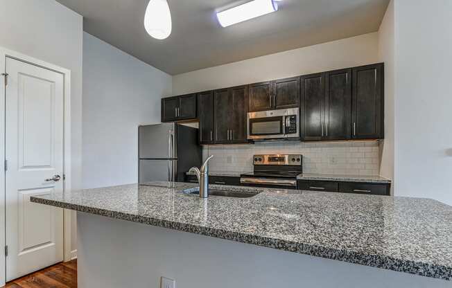 Kitchen with granite countertops and dark wood cabinets at The View at Old City, Philadelphia