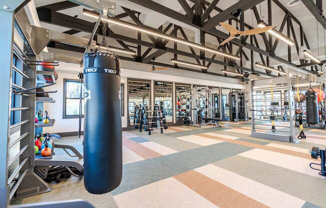 A gym with a punching bag hanging from the ceiling.
