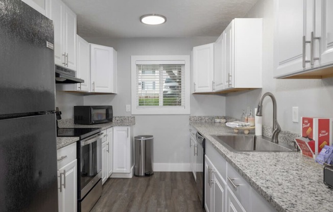 a kitchen with granite counter tops and white cabinets  at Kirkwood Meadows, Pocatello