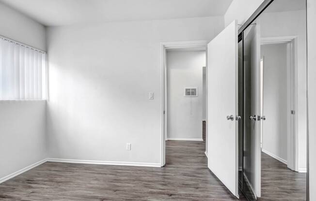 an empty room with white walls and a sliding glass door