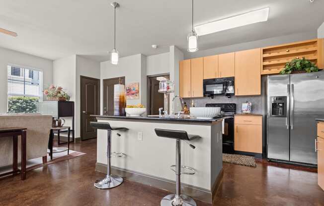 a kitchen with stainless steel appliances and an island with bar stools