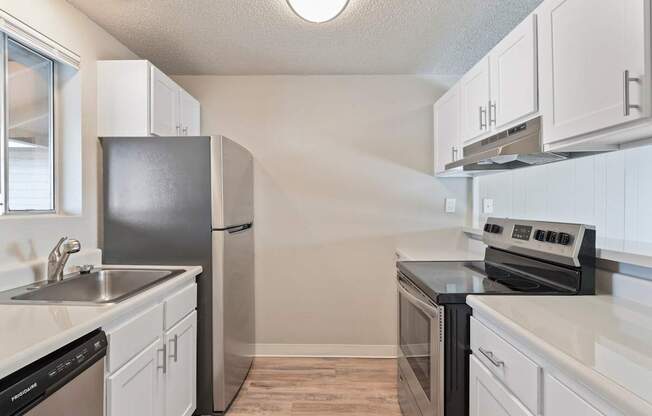 A kitchen with white cabinets and black appliances.