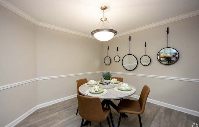 A dining room with a round table set for two.