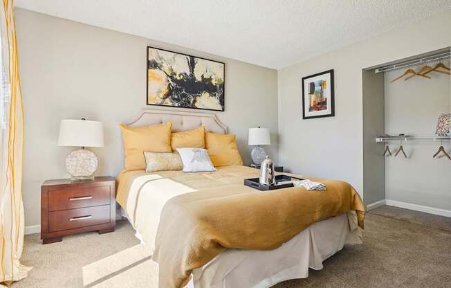 A bedroom with a bed, nightstand, and a painting on the wall.