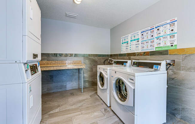 a laundry room with two washing machines and a counter with a sink and a refrigerator