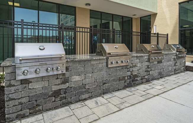 a retaining wall with three grills in front of a building  at The Icon, Richmond