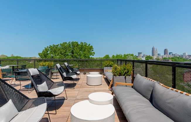 a rooftop deck with couches and chairs and a view of the Cleveland skyline at TREO Apartments, Cleveland, 44116
