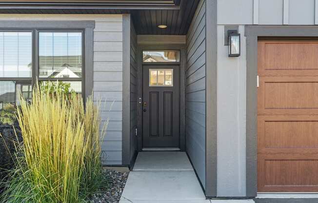 the front entrance of a house with a black door