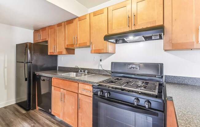 a kitchen with black appliances and wooden cabinets