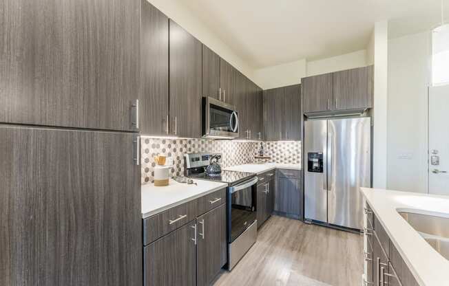Updated Kitchen With Black Appliances and wooden cabinets at Residences at 3000 Bardin Road, Grand Prairie, Texas