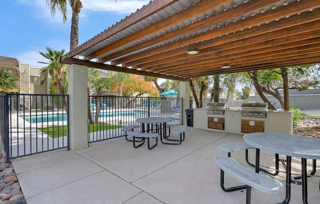 A patio with a table and chairs under a roof.