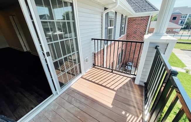 a view of the front porch of a white house with a balcony and a door