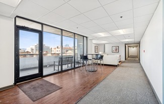 A long hallway with a table and chairs at the end.
