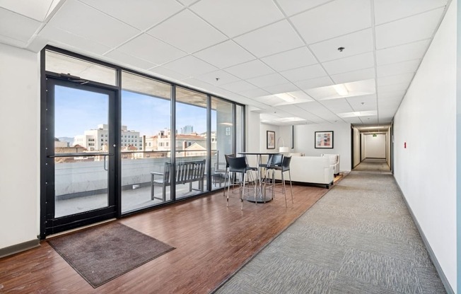A long hallway with a table and chairs at the end.