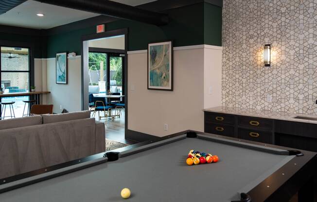 a pool table in a living room with a bar  at One Riverside Apartments, Chattanooga, TN, 37403