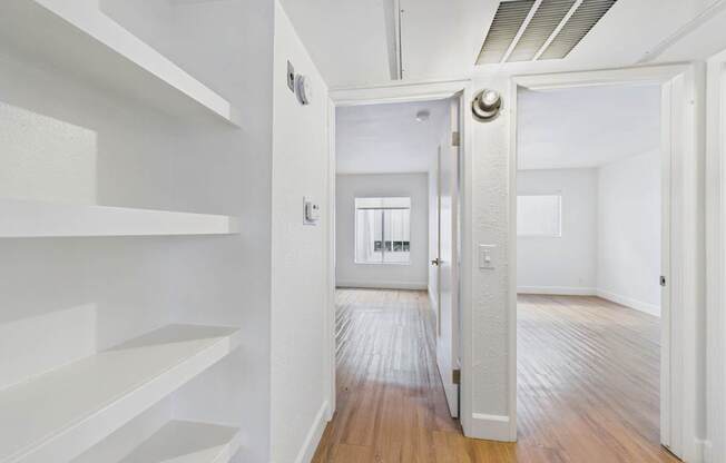 A hallway with white walls and wooden floors.