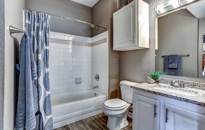 Model bathroom with tile tub and shower and granite countertops